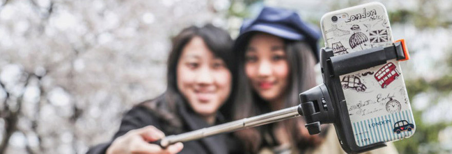 Des personnes se prenant en photo avec une perche à selfie